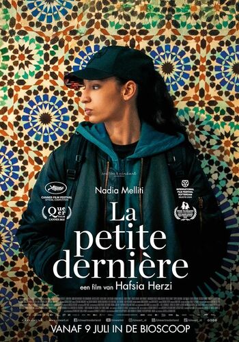 Film poster voor "La petite dernière", met een vrouw in een zwarte jas, staande voor een kleurrijke mozaïek achtergrond.