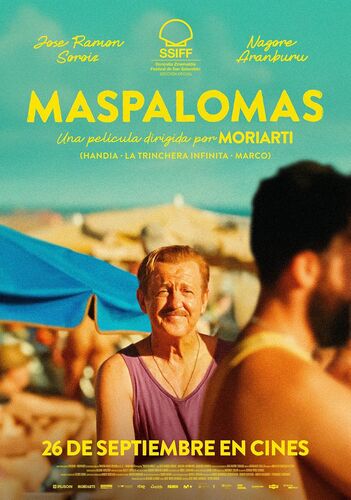 Een man glimlacht op een strand tussen kleurige parasols; film "Maspalomas" komt uit op 26 september.