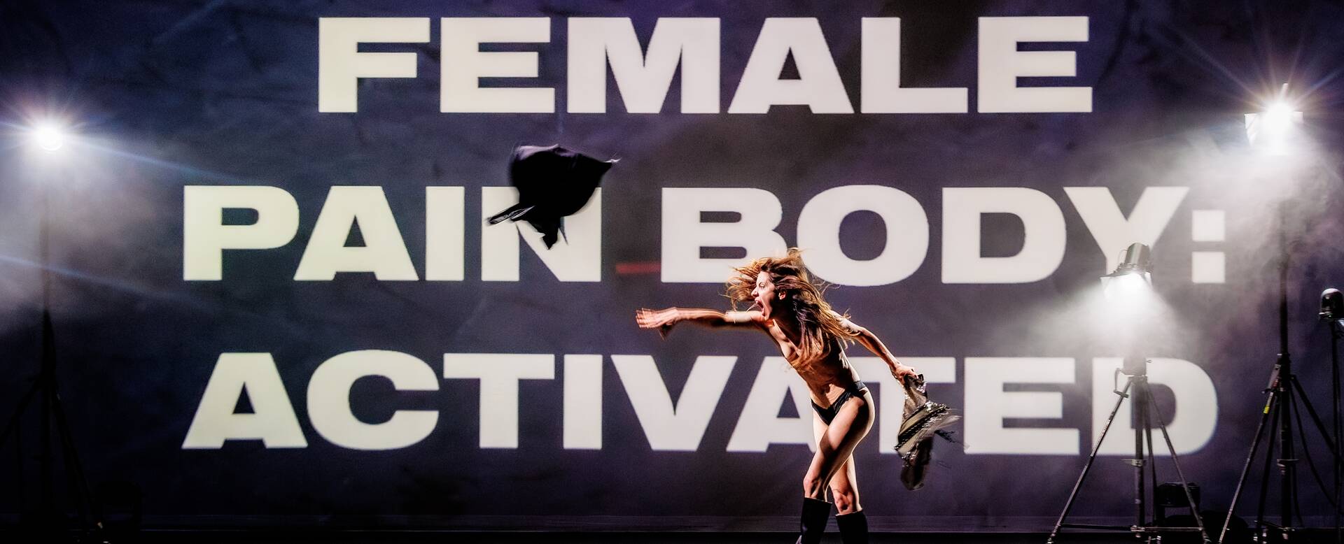 Vrouw in een dynamische pose voor een grote achtergrondtekst: "FEMALE PAIN BODY: ACTIVATED".