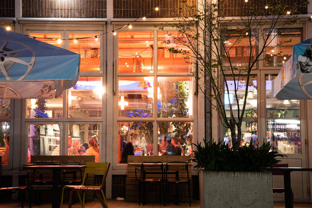 Een uitzicht op verlichte restaurantramen van de Verkadefabriek