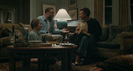 Groep vrienden geniet van een gezellige avond bij elkaar in een woonkamer, met gesprekken en gelach.